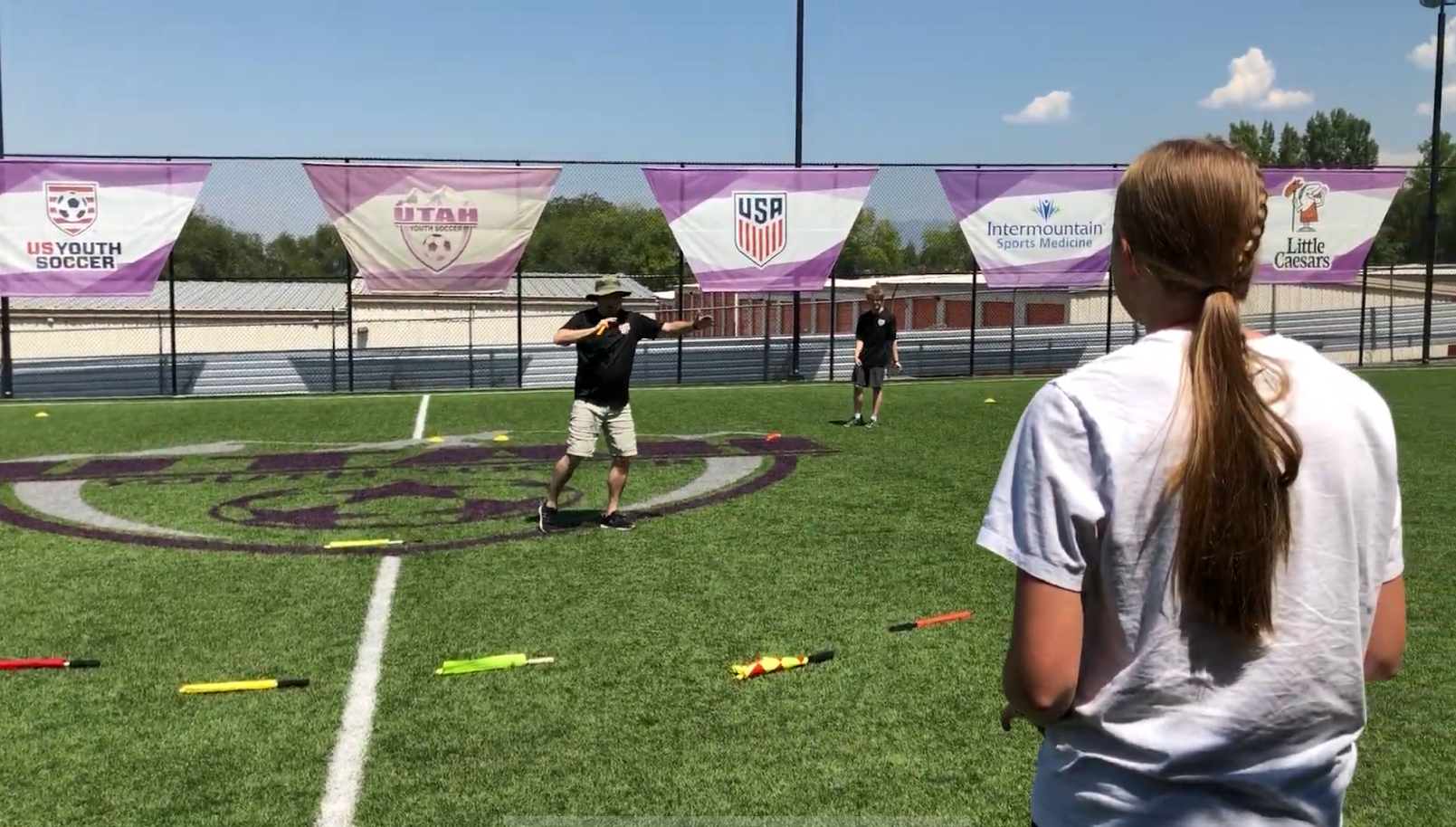 A classroom of referees holding flags in the air during an IREF clinic