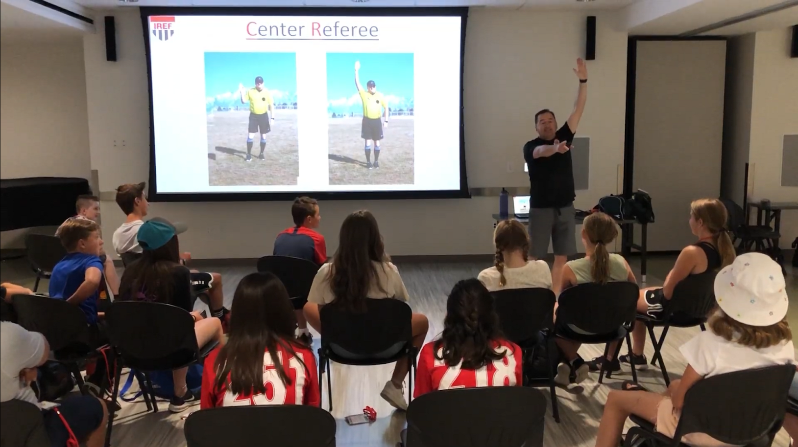 Mark instructing a group of referees in a classroom clinic setting